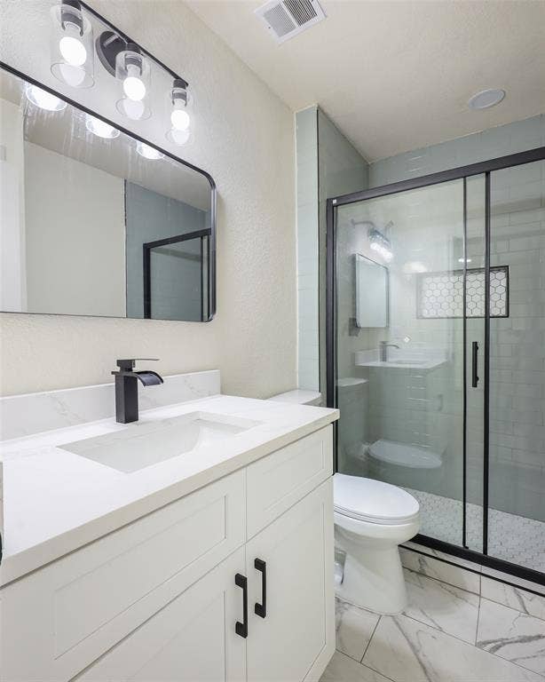 White vanity with integrated sink, black waterfall faucet, and white countertop