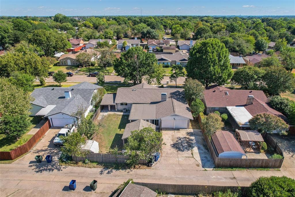 Expansive residential neighborhood with mature trees, offering a private backyard area and paved driveway