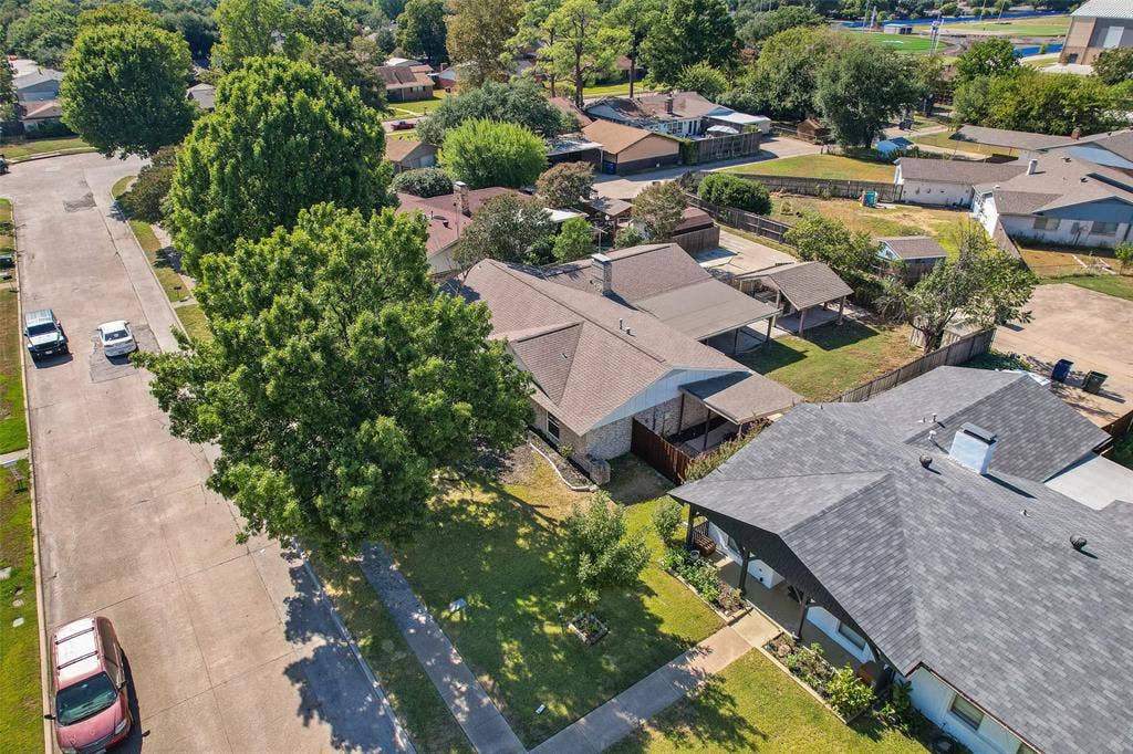 Property featuring a gabled roof, covered patio, and mature landscaping