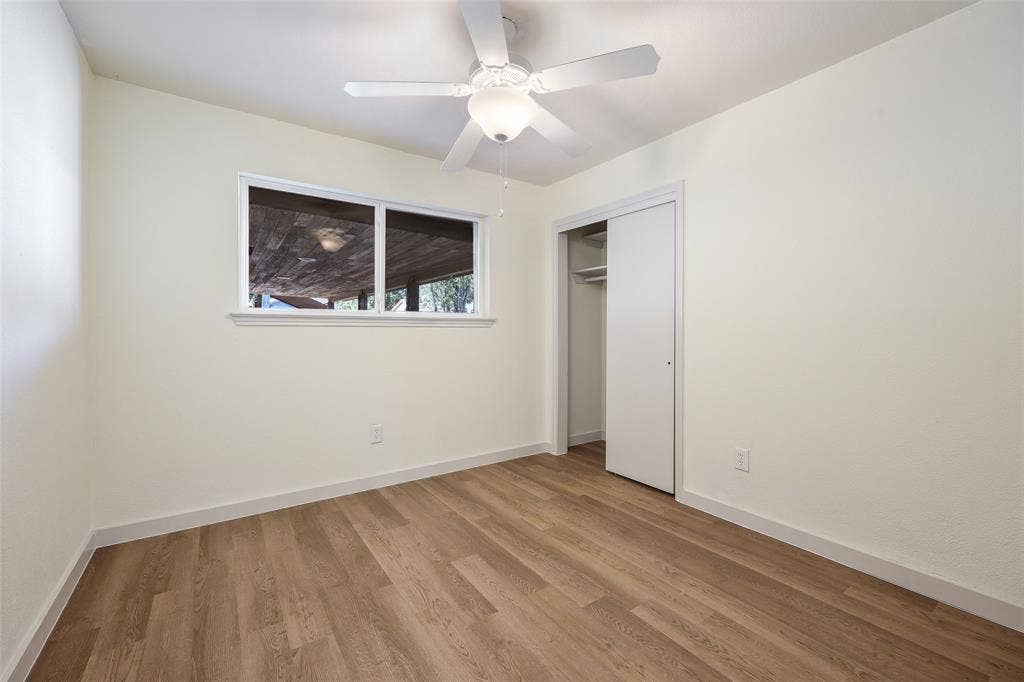 Smooth-finish walls, wood-finish flooring, and a ceiling fan with integrated lighting