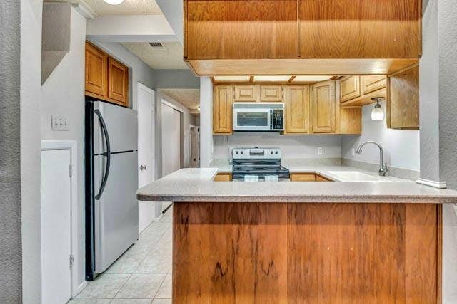 2503 Shady Ridge Drive, Bedford, TX 76021 Kitchen featuring wood cabinetry, a peninsula countertop, stainless steel refrigerator, built-in microwave, and tile flooring