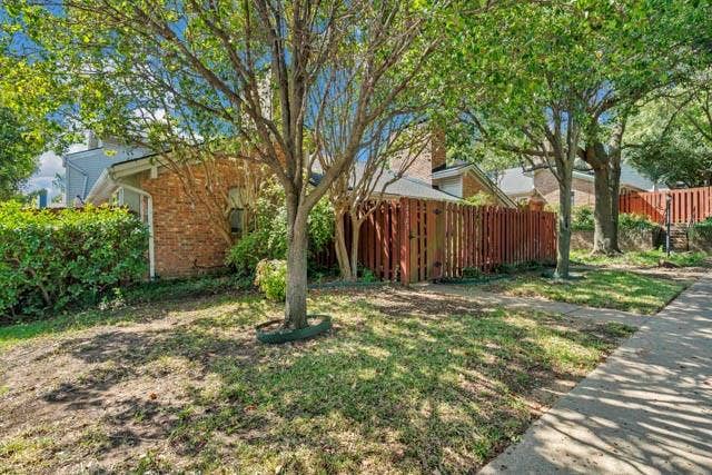 2503 Shady Ridge Drive, Bedford, TX 76021 Brick exterior facade featuring a vertical wood privacy fence and mature trees