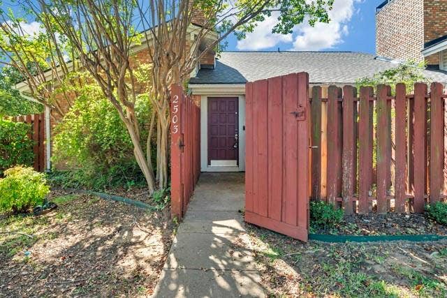 2503 Shady Ridge Drive, Bedford, TX 76021 Brick exterior featuring a private gated entry, a paneled front door, and a paved walkway