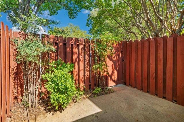 2503 Shady Ridge Drive, Bedford, TX 76021 Concrete patio area enclosed by a solid wood privacy fence with mature tree canopy and established landscaping
