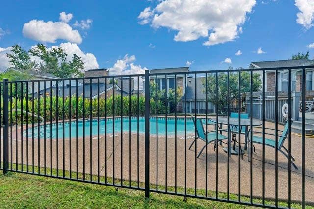 2503 Shady Ridge Drive, Bedford, TX 76021 In-ground swimming pool with a concrete surround, enclosed by a black metal perimeter fence