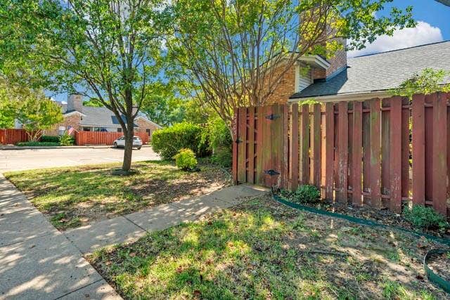 2503 Shady Ridge Drive, Bedford, TX 76021 Wood-slat privacy fencing with gated access, concrete sidewalk, masonry chimney, and mature shade trees