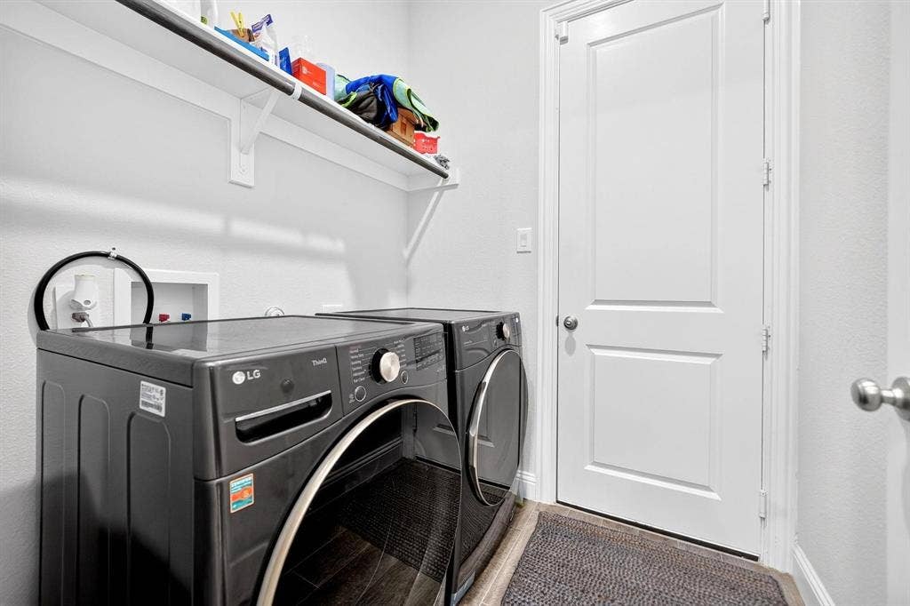 Laundry area featuring wood-finish flooring, a wall-mounted shelving unit, and a two-panel interior door