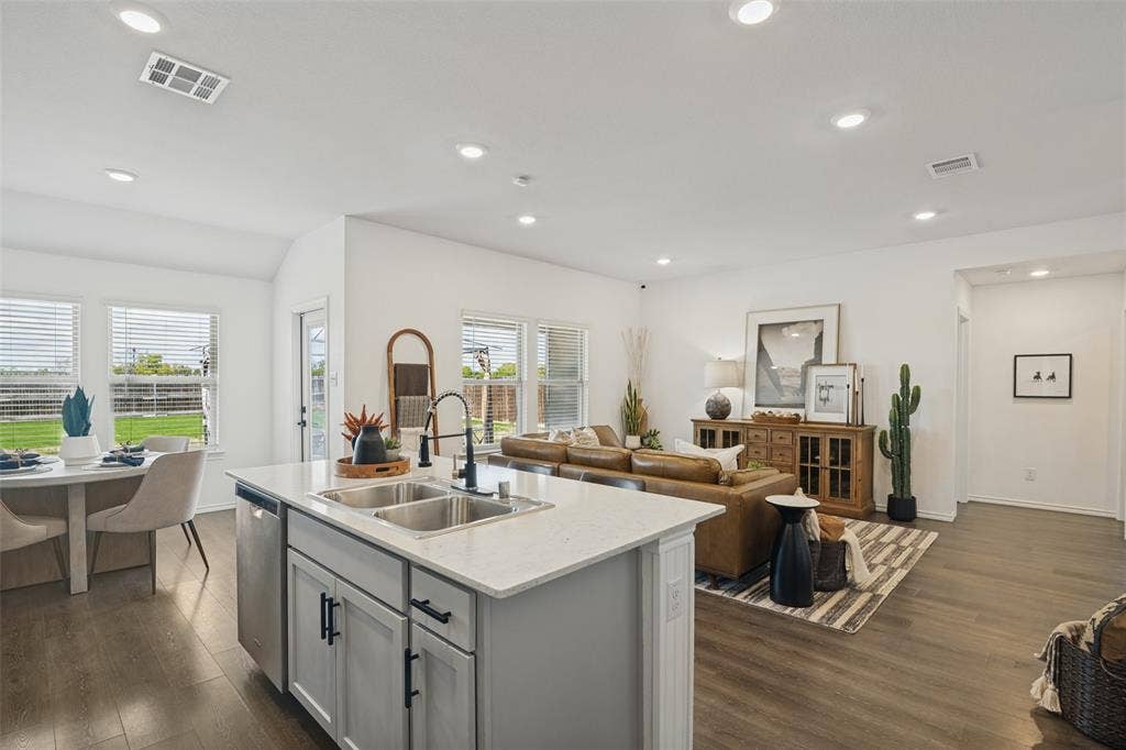 1506 Buckaroo Lane, Josephine, TX 75189 Kitchen featuring an island with a light-toned solid surface countertop, undermount stainless steel double-basin sink, and matte black fixtures