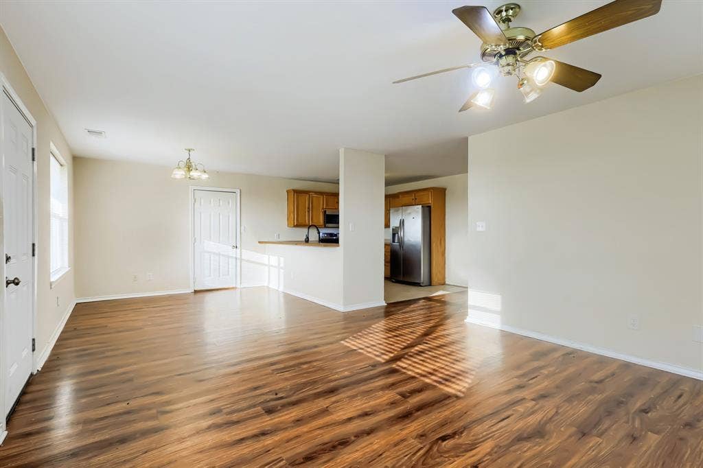 112 Sebastian Lane, Josephine, TX 75173 Open-concept interior featuring laminate wood-finish flooring, a ceiling fan with integrated lighting, kitchen cabinetry, and stainless steel appliances