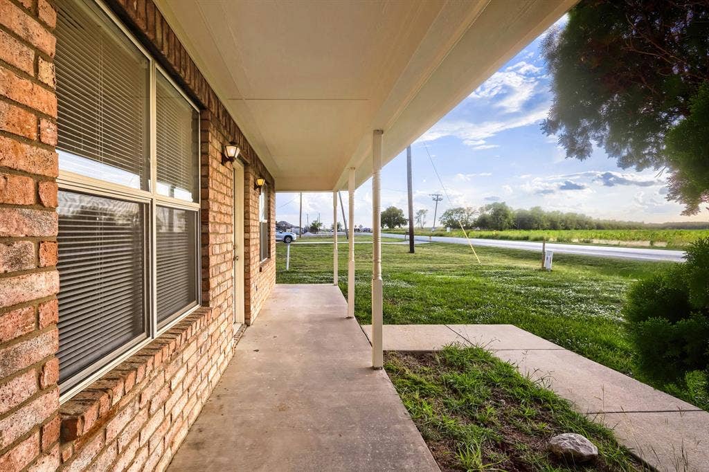 112 Sebastian Lane, Josephine, TX 75173 Covered porch featuring brick exterior walls, concrete flooring, and support columns