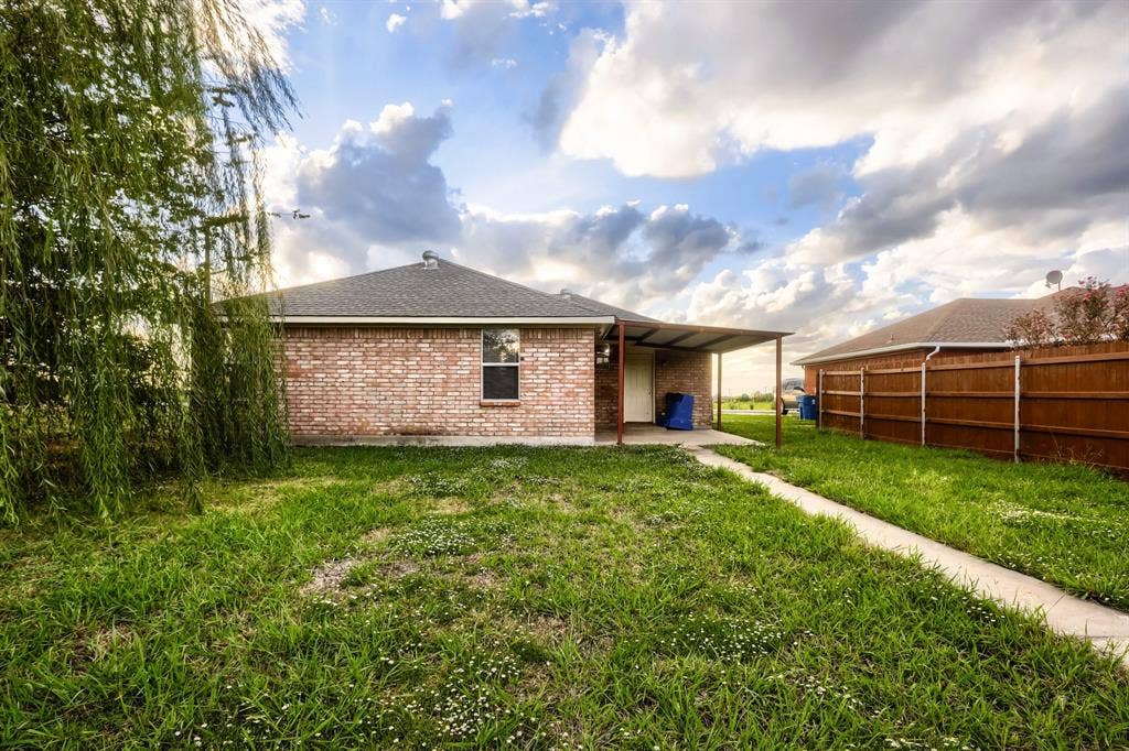 112 Sebastian Lane, Josephine, TX 75173 Brick exterior featuring a covered patio, concrete walkway, and wood privacy fencing