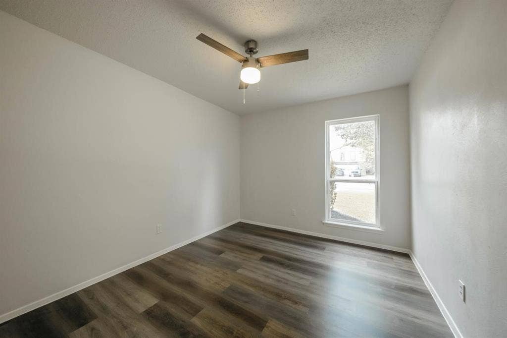 1903 Arvada Drive, Richardson, TX 75081 Room featuring wood-finish flooring, a ceiling fan with integrated lighting, and a single-pane window