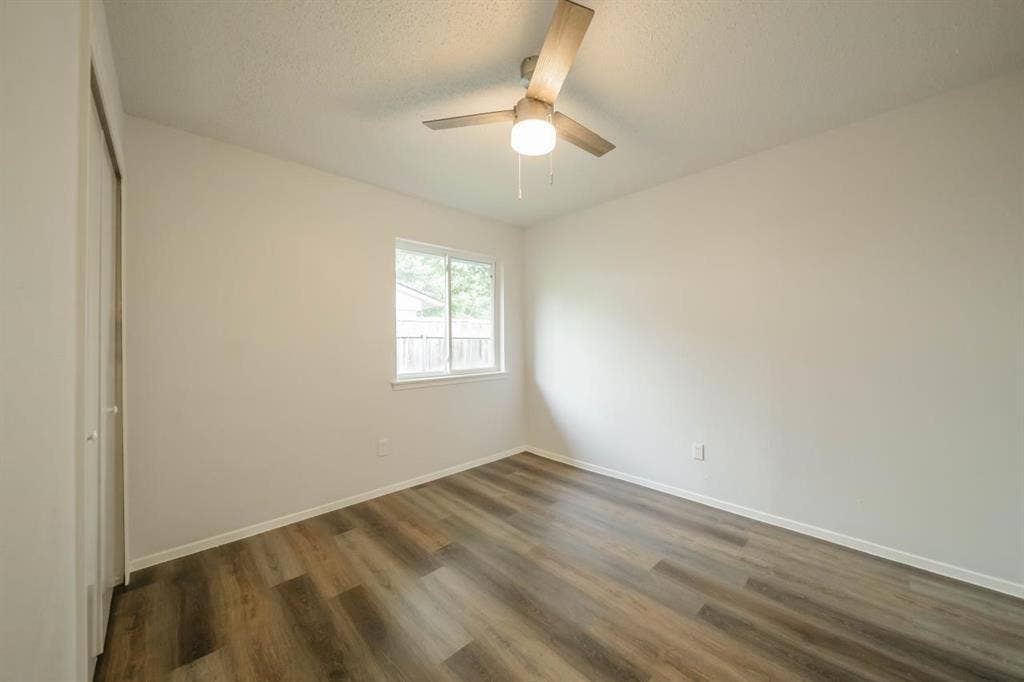 1903 Arvada Drive, Richardson, TX 75081 Interior room featuring wood-finish flooring, a neutral color palette, a ceiling fan with integrated lighting, and a window with a slider mechanism