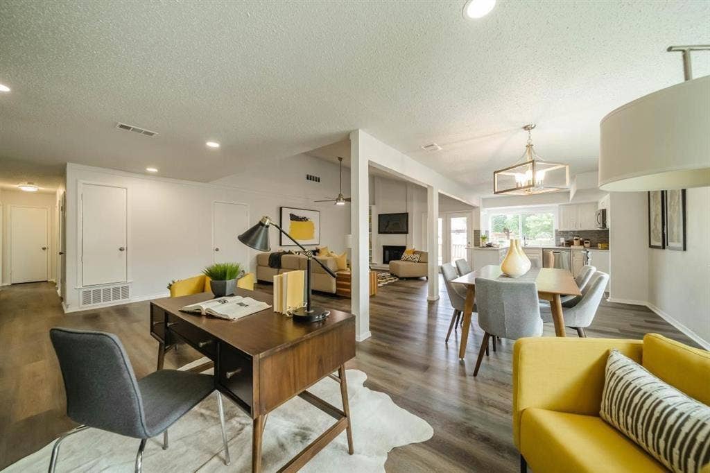 1903 Arvada Drive, Richardson, TX 75081 Open-concept floor plan featuring wood-finish flooring, recessed lighting, a modern geometric chandelier, and a wood-burning fireplace with a tile surround