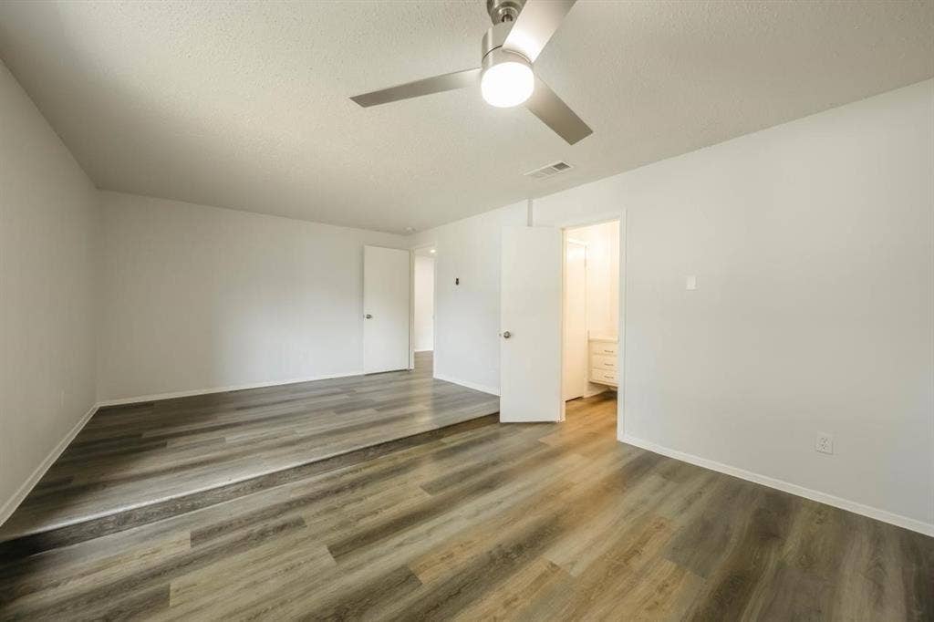 1903 Arvada Drive, Richardson, TX 75081 Multi-level interior space featuring wood-finish flooring, a contemporary brushed nickel ceiling fan with integrated light fixture, and neutral wall tones