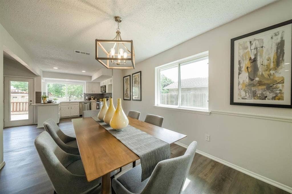 1903 Arvada Drive, Richardson, TX 75081 Dining area featuring wood-finish flooring, a contemporary geometric metal chandelier, chair rail molding, and a sliding glass door