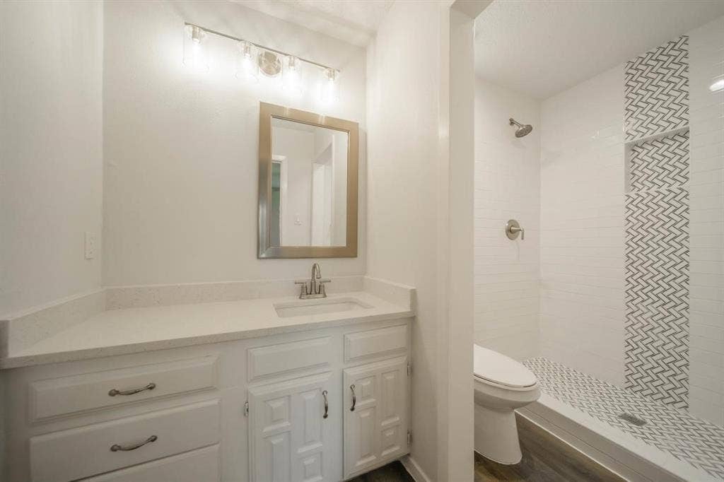 1903 Arvada Drive, Richardson, TX 75081 Bathroom vanity featuring white cabinetry, a light-toned countertop, and integrated rectangular sink