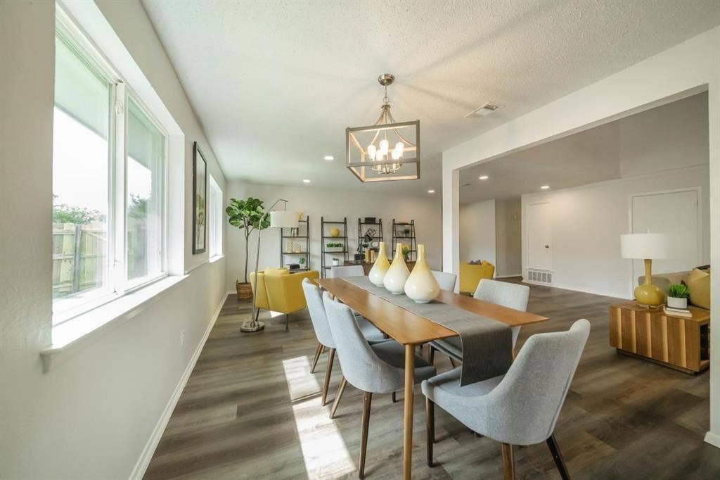 1903 Arvada Drive, Richardson, TX 75081 Open-concept interior featuring wood-finish flooring, a contemporary geometric pendant light fixture, and large windows with horizontal sills