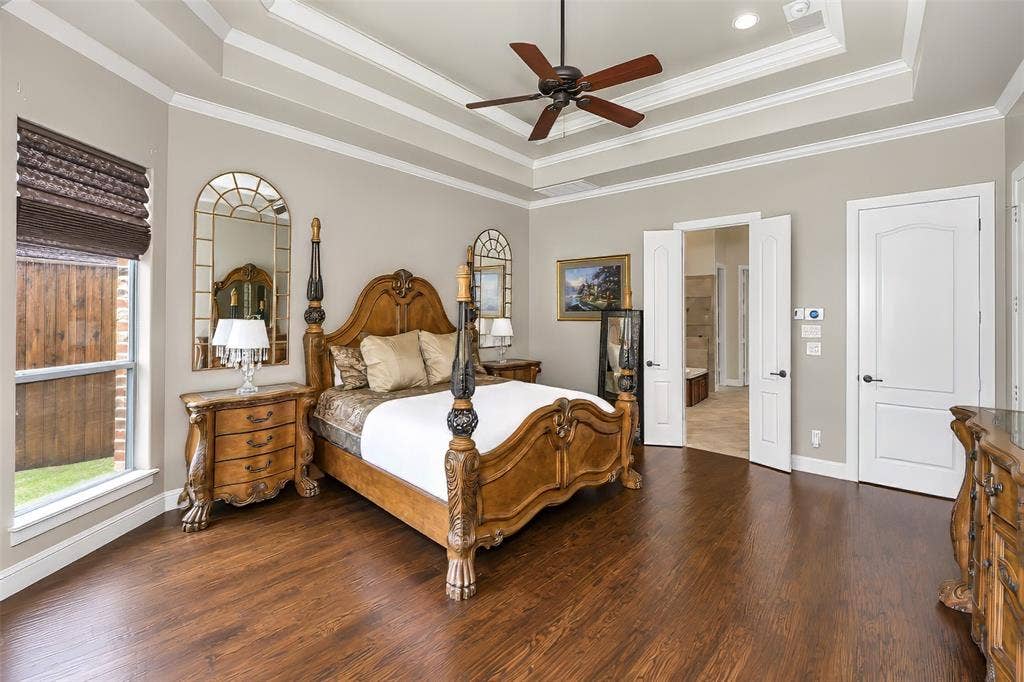 6620 Cedar Grove Drive, North Richland Hills, TX 76182 The primary bedroom features a tiered ceiling detail and wood flooring.