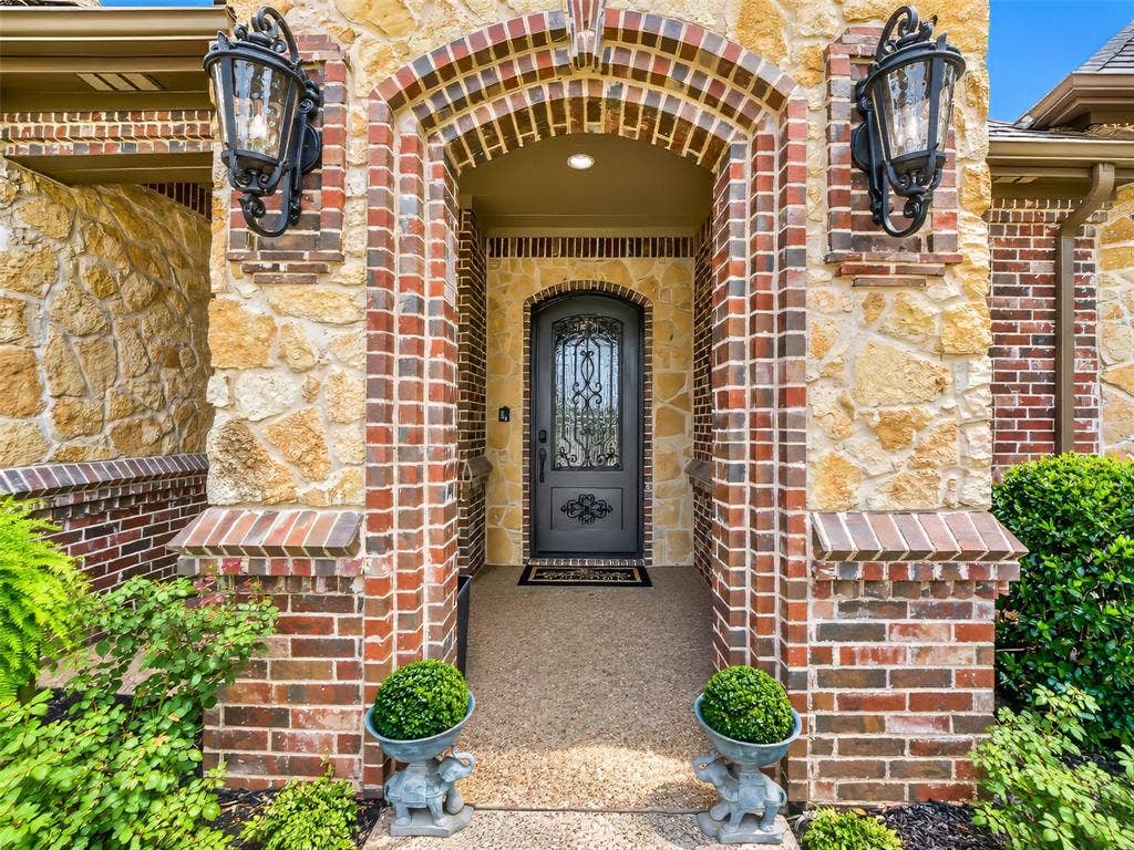 6620 Cedar Grove Drive, North Richland Hills, TX 76182 Stately stone and brick facade with custom iron front entry door.