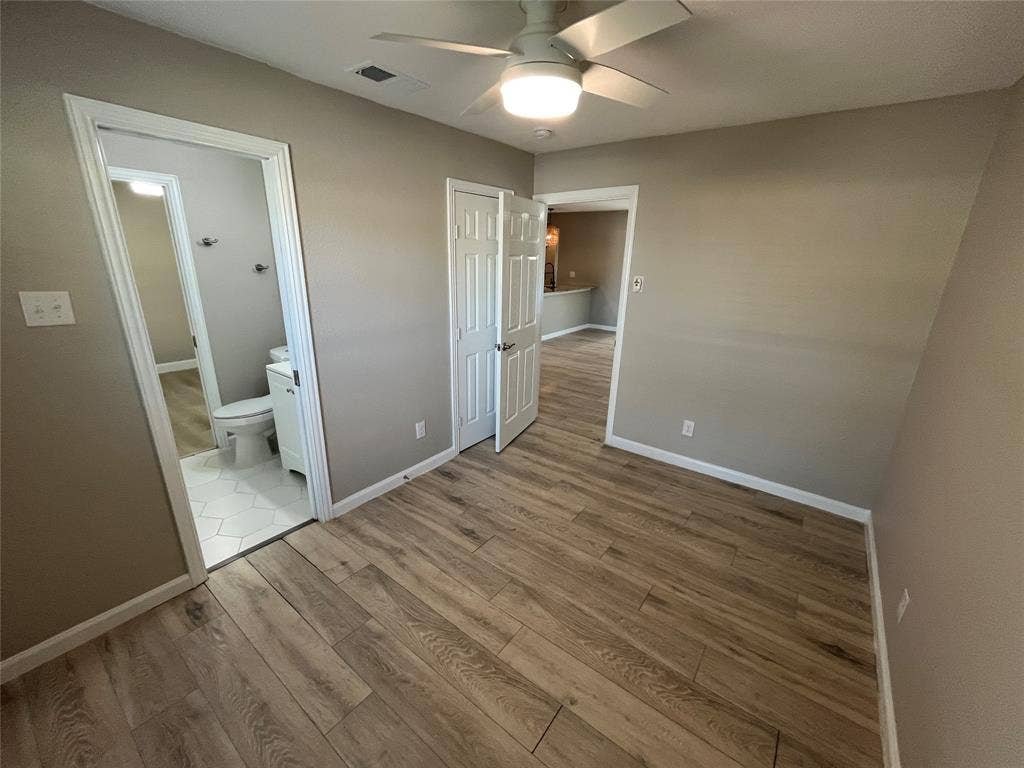600 Royal Crest Drive, Richardson, TX 75081 Wood-finish flooring, neutral wall tones, ceiling fan with integrated lighting, paneled interior doors, and hex-patterned tile flooring