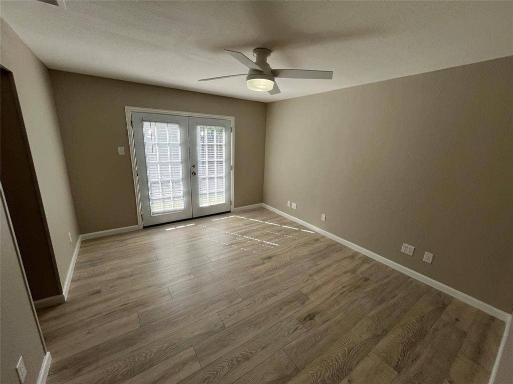 600 Royal Crest Drive, Richardson, TX 75081 Room featuring wood-finish flooring, white French doors, and a ceiling fan with integrated lighting