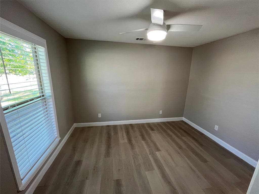 600 Royal Crest Drive, Richardson, TX 75081 Interior room featuring wood-finish flooring, neutral wall paint, and a ceiling-mounted light fixture with a fan