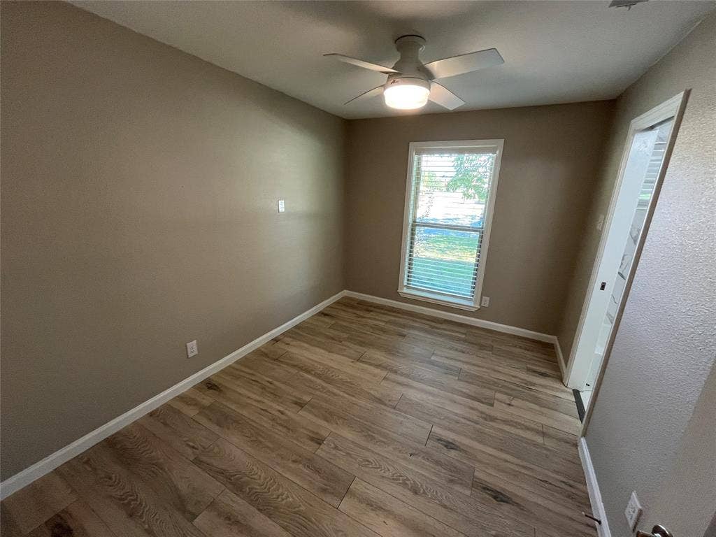 600 Royal Crest Drive, Richardson, TX 75081 Room featuring wood-finish flooring, a neutral wall palette, an integrated ceiling fan with light fixture, and a window with blinds