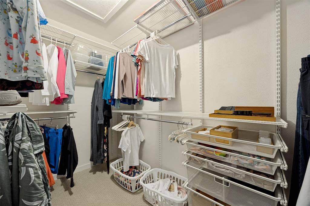 Walk-in closet featuring adjustable wire shelving, integrated hanging rods, and pull-out wire storage drawers