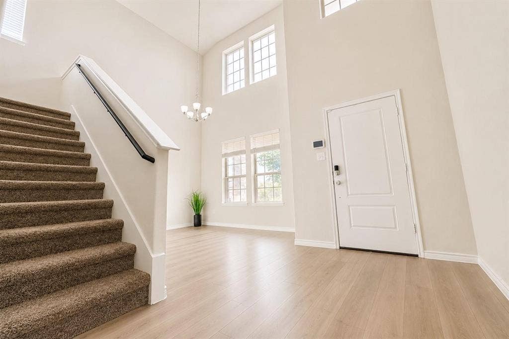 Entryway boasts vaulted ceilings and elegant stairway