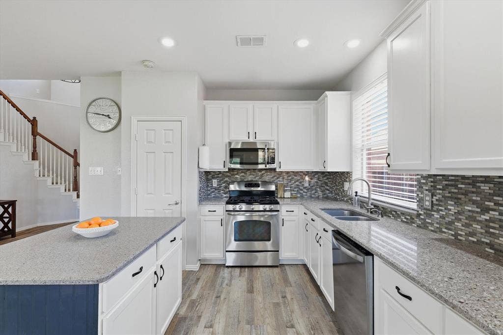 A stainless steel gas range, over-the-range microwave & ample preparation space make the kitchen both practical & appealing.