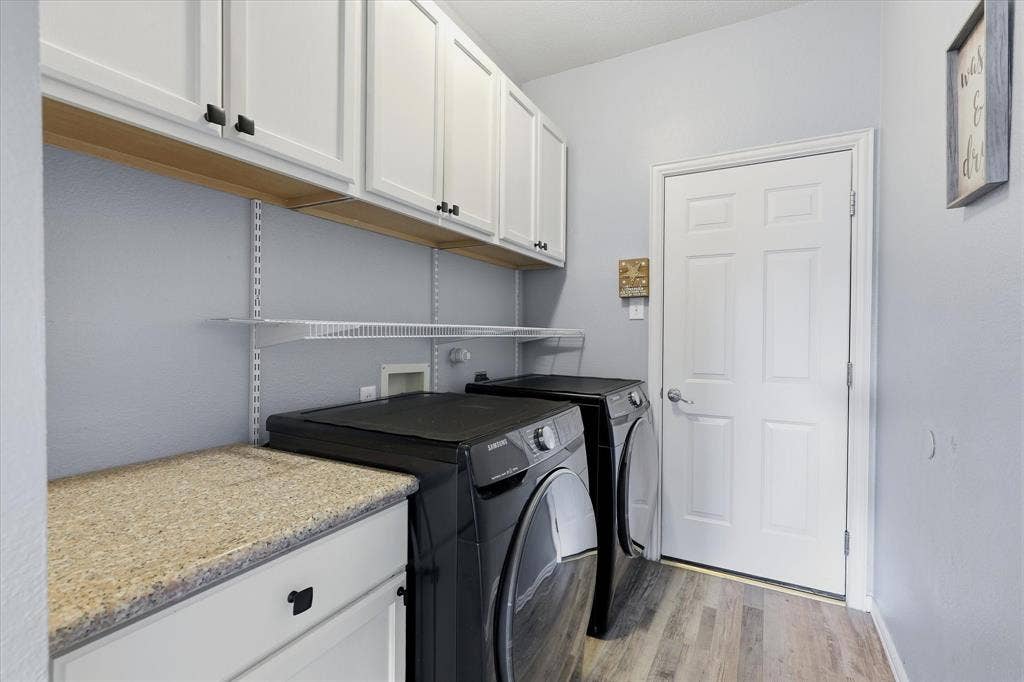 Upper cabinets, open shelving & a folding counter add practical storage to the laundry room.