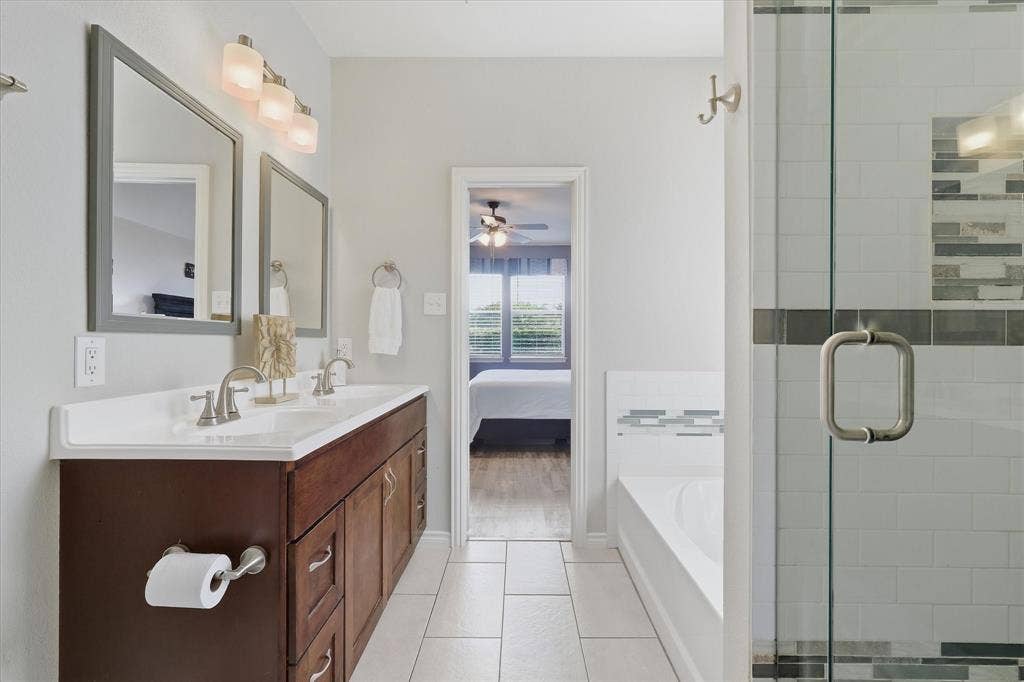 Dual sinks, framed mirrors & abundant cabinet and drawer storage enhance the primary bath.