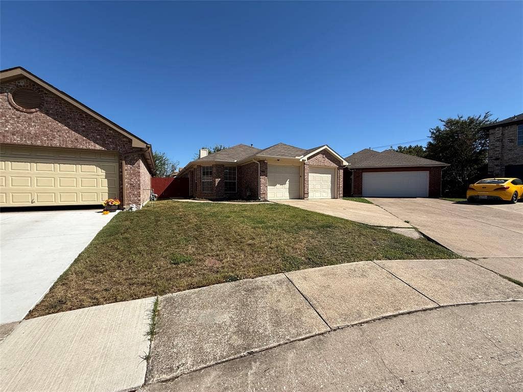 5210 Welbeck Court, Garland, TX 75043 Brick exterior residence featuring a two-car garage, concrete driveway, and front lawn