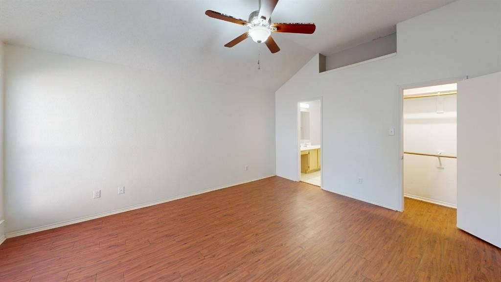 5210 Welbeck Court, Garland, TX 75043 Room featuring vaulted ceilings, wood-finish flooring, a ceiling fan with integrated lighting, and a built-in closet
