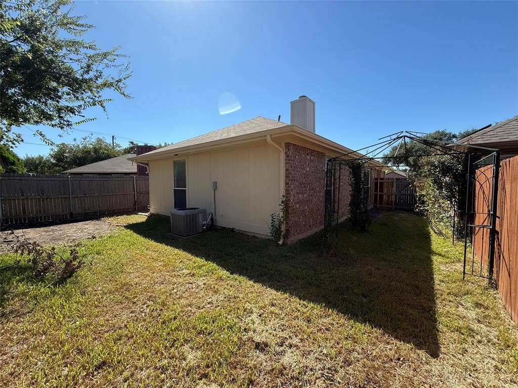 5210 Welbeck Court, Garland, TX 75043 Exterior featuring a brick and siding facade, composition shingle roof, chimney, and fenced backyard with a metal garden trellis