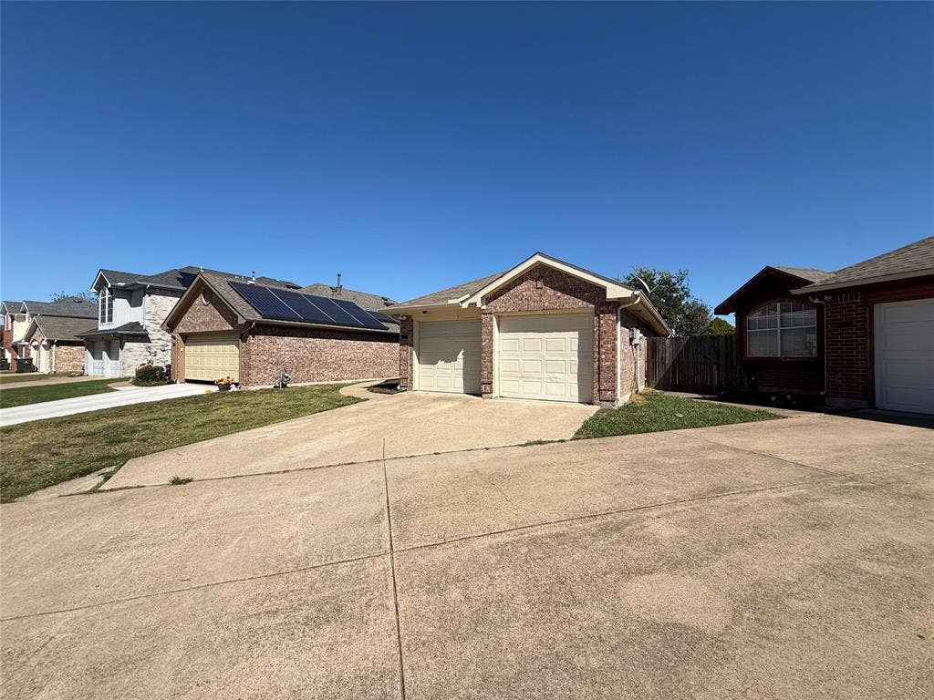 5210 Welbeck Court, Garland, TX 75043 Single-story brick exterior featuring a two-car garage, concrete driveway, and gabled roofline
