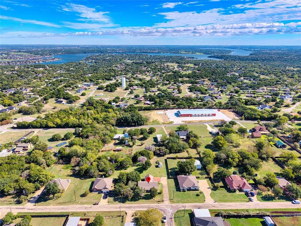 Aerial perspective of a detached residential property situated on a lot with established trees and expansive lawn space