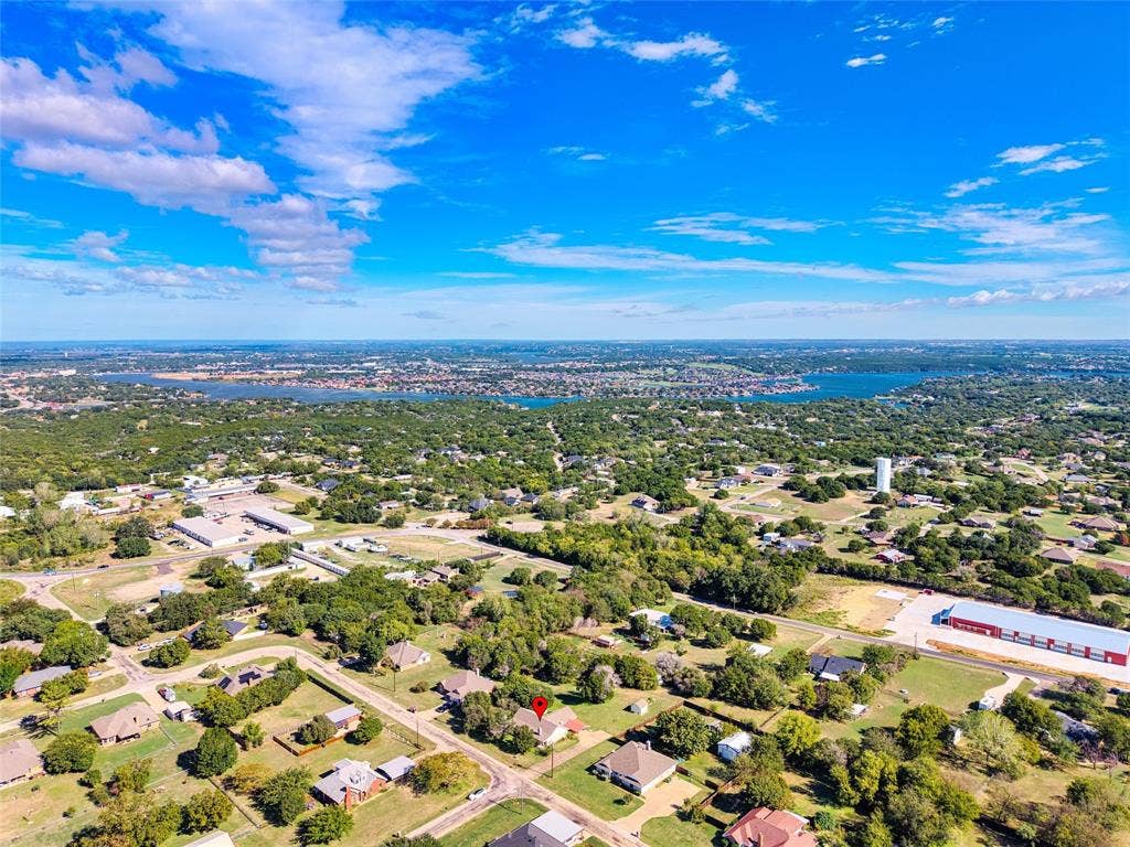 Aerial perspective of a property situated on a generous lot with extensive mature tree canopy and proximity to expansive water features