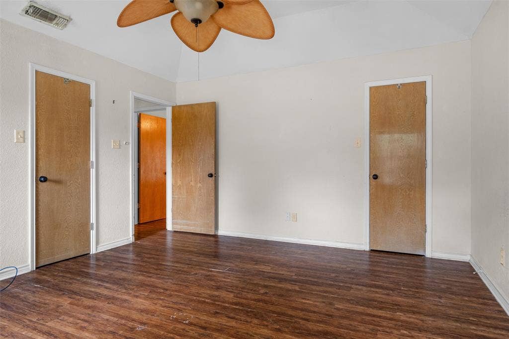 Vaulted ceiling with a wood-finish paddle ceiling fan and wood-finish flooring throughout