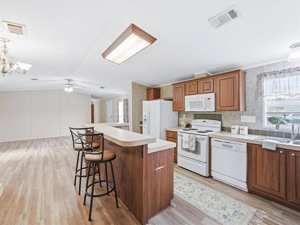 4113 Goliad Drive, Granbury, TX 76048 Kitchen with island, eat at bar and dining table space. Window over the sink.
