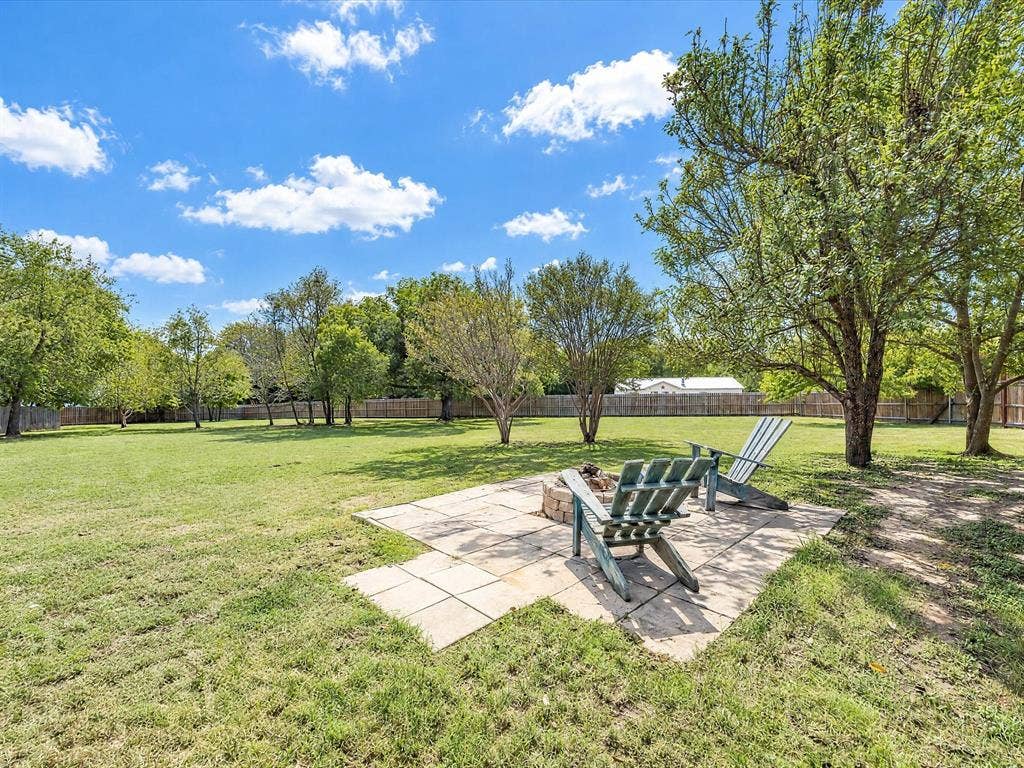 4113 Goliad Drive, Granbury, TX 76048 Fully fenced private backyard with lots of trees including peach and pear. Stone patio with firepit, enjoy views of the stars.