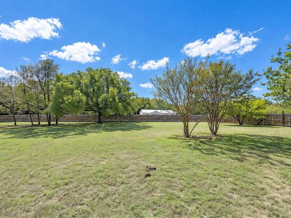 4113 Goliad Drive, Granbury, TX 76048 Fully fenced private backyard with lots of trees including peach and pear. Stone patio with firepit, enjoy views of the stars.