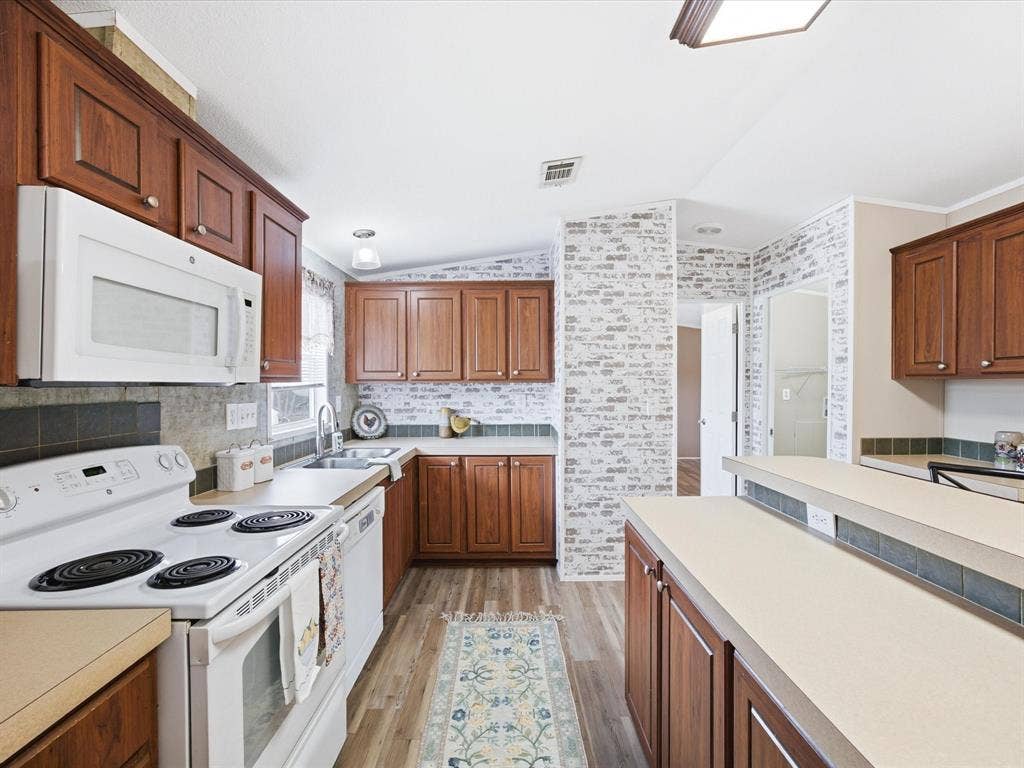 4113 Goliad Drive, Granbury, TX 76048 Kitchen with island, eat at bar and dining table space. Window over the sink.
