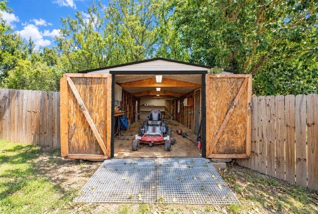 4113 Goliad Drive, Granbury, TX 76048 12x30 shop with electric, double doors, side door and ramp. Fits your tools, atv's, golf cart and mowers.
