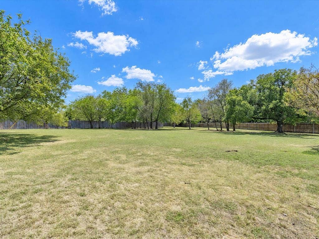 4113 Goliad Drive, Granbury, TX 76048 Fully fenced private backyard with lots of trees including peach and pear. Stone patio with firepit, enjoy views of the stars.
