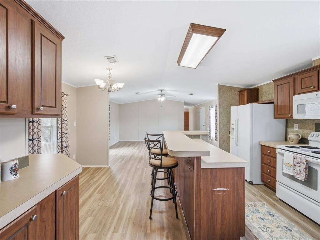 4113 Goliad Drive, Granbury, TX 76048 Kitchen with island, eat at bar and dining table space. Window over the sink.