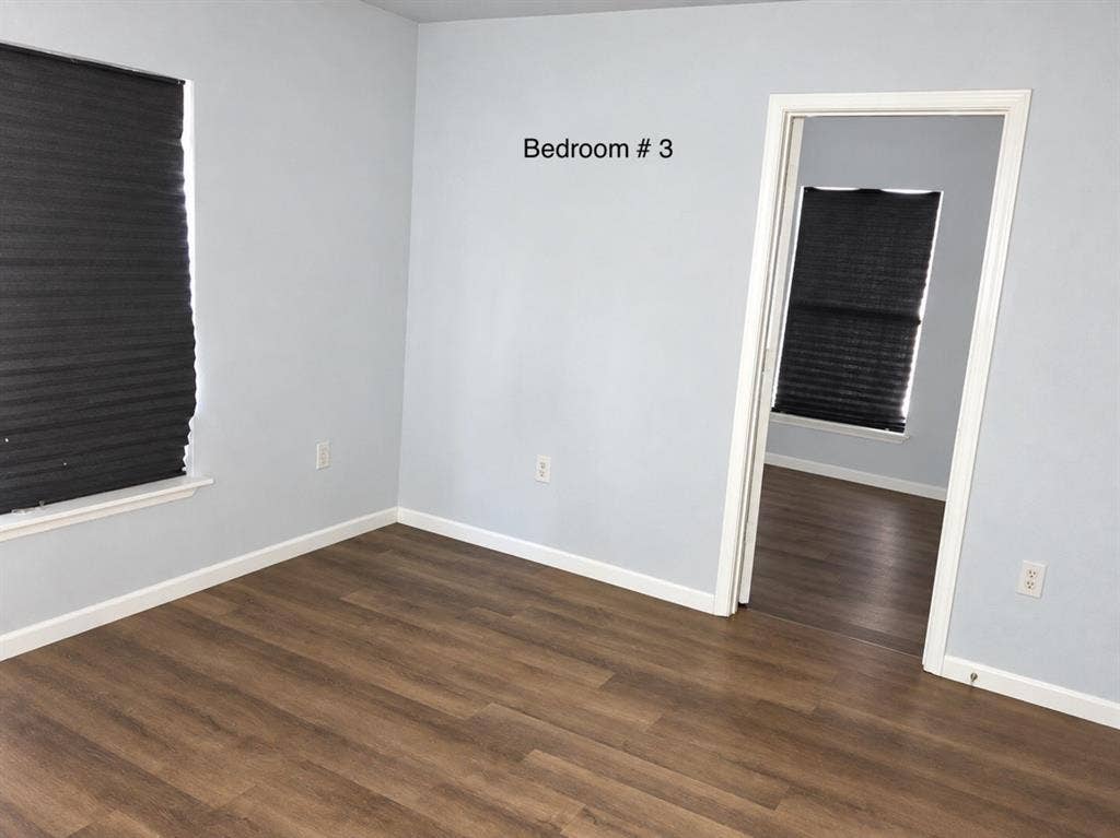 709 SW Dallas Street, Grand Prairie, TX 75051 Neutral-toned walls paired with wood-finish flooring and window treatments