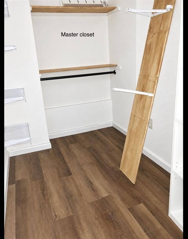 709 SW Dallas Street, Grand Prairie, TX 75051 Walk-in storage space featuring wood-finish flooring, built-in open shelving, and a mounted metal garment rod
