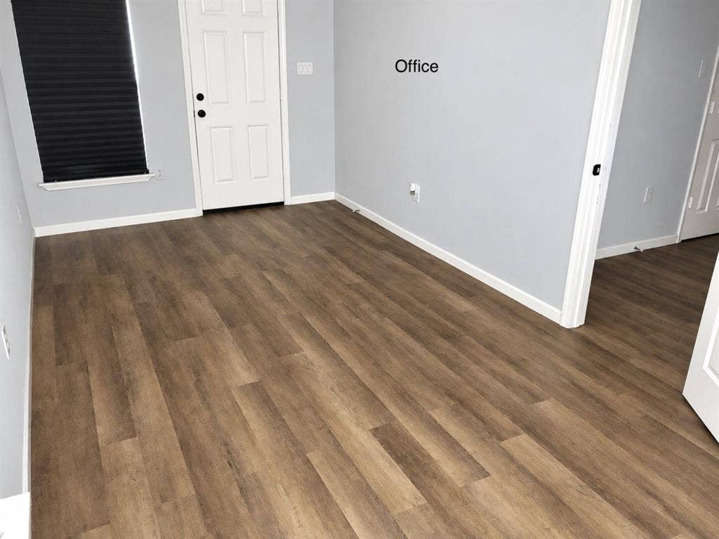 709 SW Dallas Street, Grand Prairie, TX 75051 Room featuring wood-finish flooring, neutral wall paint, a multi-panel door, and a single-hung window with a dark window shade
